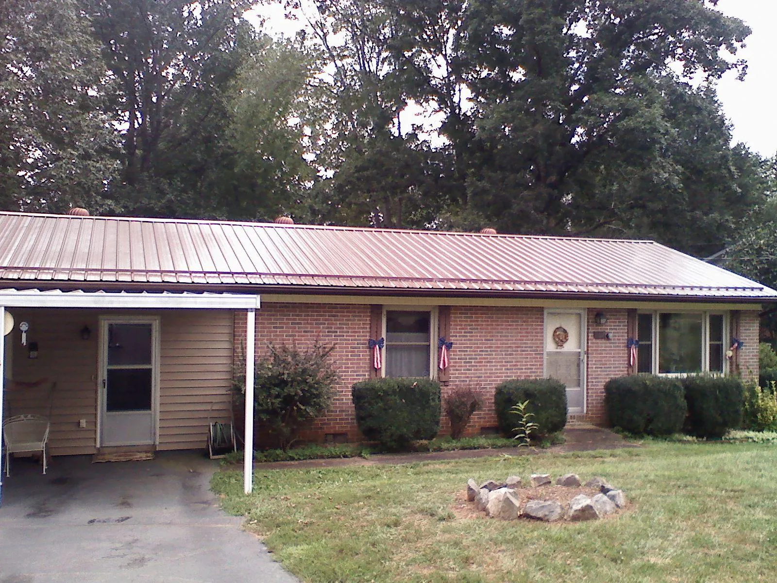 Bronze metal roof and carport on a brick ranch home — Roof Repair work by our crew in Rockville